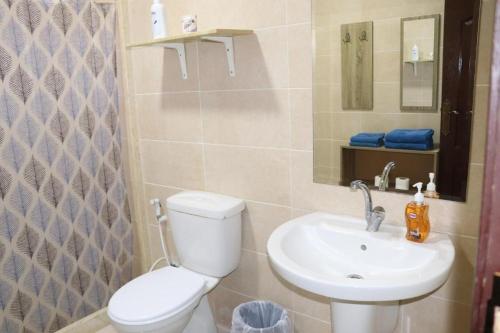 a bathroom with a toilet and a sink at Salvador Dali Apartments in Amman