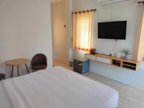 um quarto com uma cama e uma televisão de ecrã plano em กุหลาบแก้ว รีสอร์ท em Ban Mae Lai