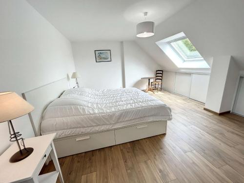 ein weißes Schlafzimmer mit einem Bett und einem Dachfenster in der Unterkunft Maison Jullouville, 5 pièces, 7 personnes - FR-1-361-511 in Jullouville-les-Pins