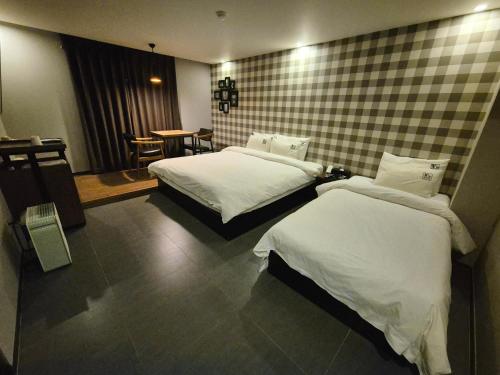 a hotel room with two beds and a table at No. 25 Hotel Myeongji Oceanc City Business in Busan