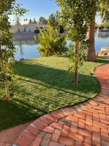 a brick walkway with two trees in a park at Water Front Sweet Home in Mesa