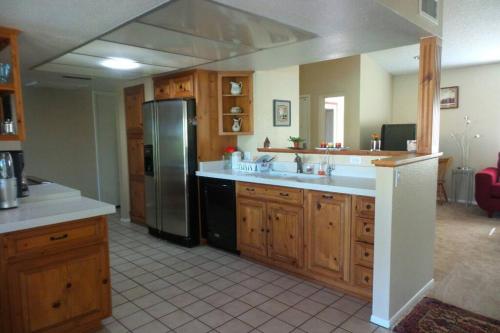a kitchen with wooden cabinets and a stainless steel refrigerator at Water Front Sweet Home in Mesa