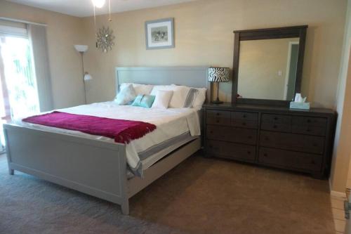 a bedroom with a bed with a dresser and a mirror at Water Front Sweet Home in Mesa