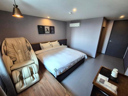 No. 25 Hotel Myeongji Oceanc City Business في بوسان: غرفه فندقيه بسرير وكرسي