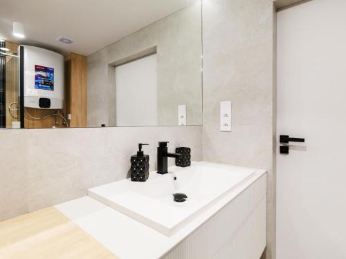 a bathroom with a white sink and a mirror at Holiday apartment near the beach in Rowy in Rowy