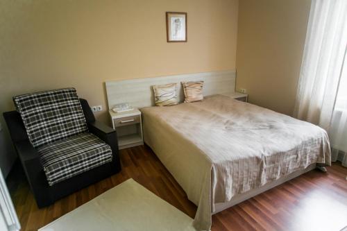 a bedroom with a bed and a chair at Tulipan Hotel Aquapark in Vyshkove