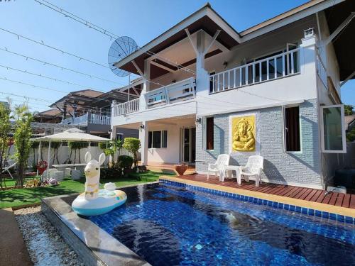 a house with a swimming pool in front of a house at D34长住优惠房-芭提雅市中心高端4间卧室泳池别墅 in Pattaya