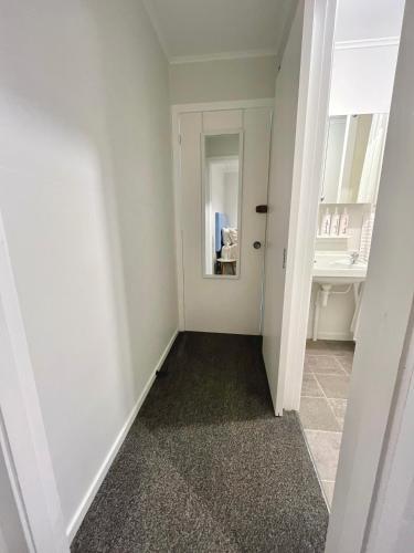 a hallway with a mirror and a sink at House of Somer in Matamata