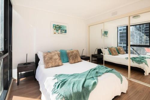 a bedroom with a large bed and a window at Melbourne CBD Apt With A C Balcony & Pool in Melbourne