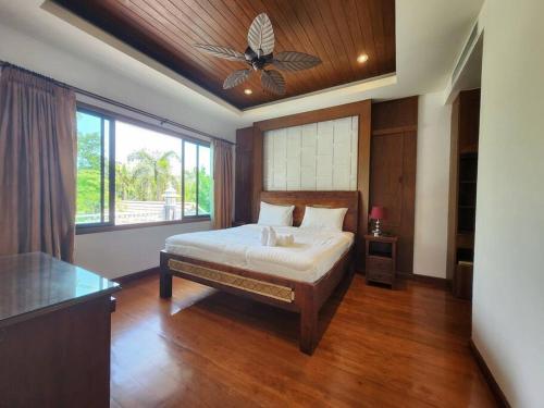 a bedroom with a bed and a ceiling fan at D30长住优惠-市中心海边高端别墅区6间卧室泳池别墅 in Pattaya Central