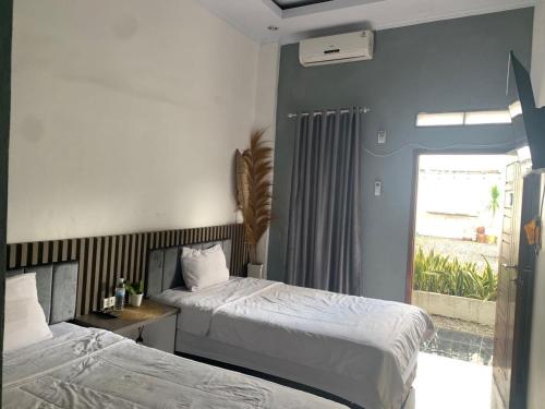 Postel nebo postele na pokoji v ubytování Oemah Ratu Hostel Syariah RedPartner