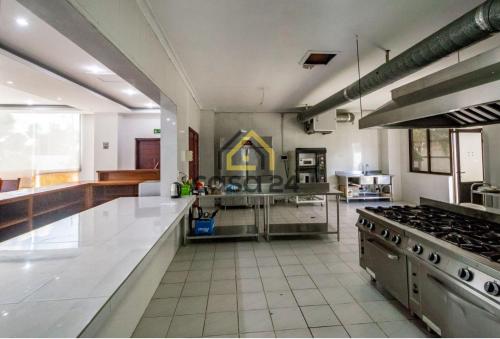 a large kitchen with a stove and a counter top at Hotel Kilimanjaro in Luanda