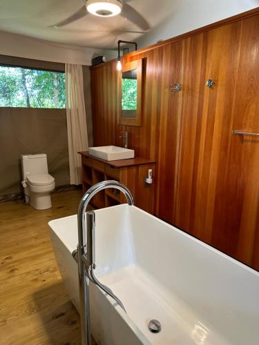 a bathroom with a white tub and a toilet at Arbol De La Vida at La Alfombra de Baru 
