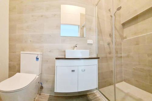 y baño con aseo, lavabo y ducha. en Exclusive location - Entire 3-bedroom in Maryborough CBD, 10ppl en Maryborough