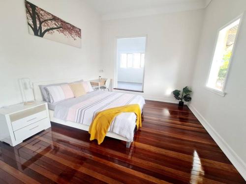 a bedroom with a bed with a yellow blanket on it at Exclusive location - Entire 3-bedroom in Maryborough CBD, 10ppl in Maryborough