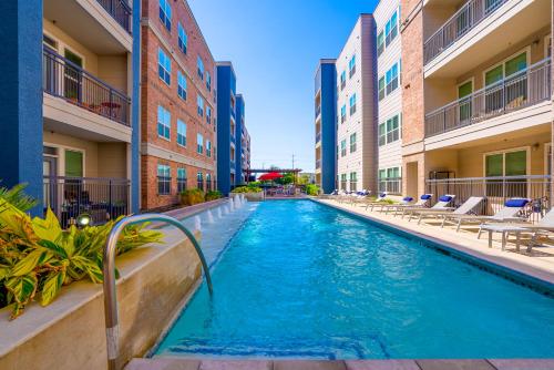 a swimming pool in an apartment complex with a hotel at Alamo Chic King Bed Refreshing Office Desk w/ Pool in San Antonio
