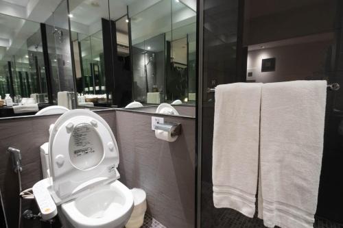 a bathroom with a toilet and a shower with towels at Stay Inn in Taipei
