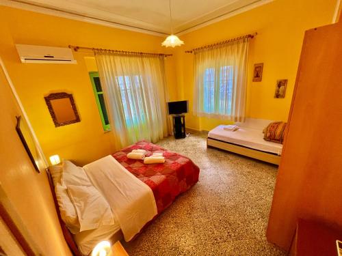 una camera con due letti e pareti gialle di Casa Levante a Cefalù