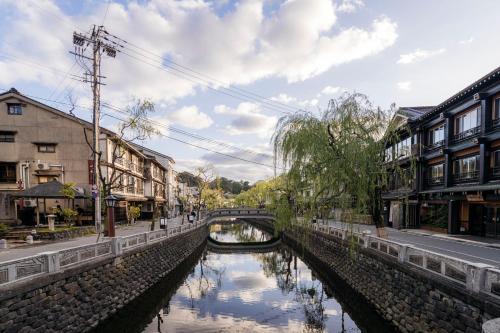 a river in a city with buildings and a bridge at Shinzan Kinosaki in Toyooka
