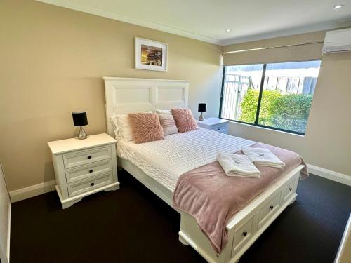 Un dormitorio con una cama grande y una ventana en Ocean View Executive Apartment 1, en Busselton