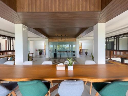 Azul de Panglao Hotel by Cocotel في بنغلاو: غرفة طعام مع طاولة وكراسي خشبية كبيرة