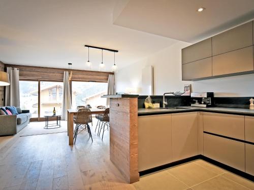 une cuisine avec un comptoir et un salon dans l'établissement Spacieux appartement avec terrasse à 2 min des pistes, parking couvert et conciergerie - FR-1-613-98, à Les Allues