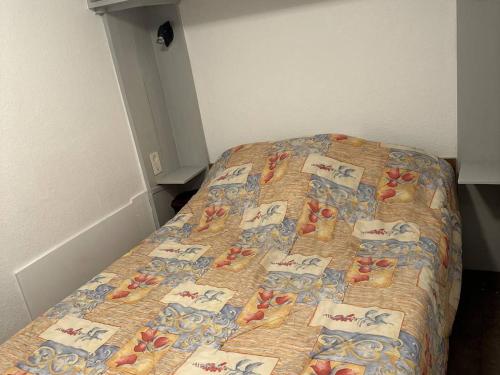 Ce lit se trouve dans un dortoir doté d'un couvre-lit avec des chats. dans l'établissement Appartement Balaruc-les-Bains, 1 pièce, 2 personnes - FR-1-680-36, à Balaruc-les-Bains