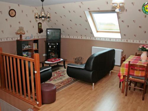 un salon avec une chaise et une télévision dans l'établissement Charmant gîte familial à Fiennes, 2 chambres, jardin privé, terrasse, proche Wissant, animaux acceptés - FR-1-376-118, à Fiennes