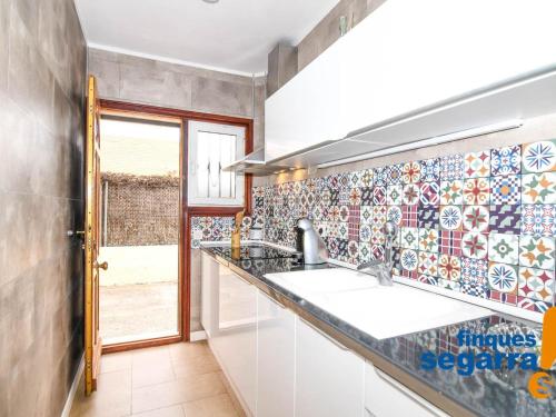 a kitchen with two sinks and a tile wall at Apartamento Roda de Berà, 3 dormitorios, 6 personas - ES-320-5 in Roda de Bará