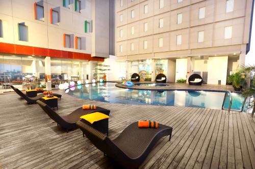 un vestíbulo de hotel con piscina y un edificio en HARRIS Hotel & Conventions Gubeng, en Surabaya