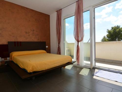um quarto com uma cama e janelas grandes em Casa Roda de Berà, 4 dormitorios, 7 personas - ES-320-22 em Roda de Bará