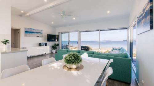 een woonkamer met een tafel en een groene bank bij Beachside in Coffin Bay