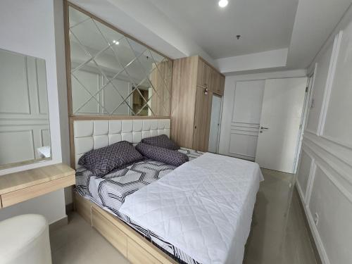 Un pat sau paturi într-o cameră la Apartermen Skylouge Makassar