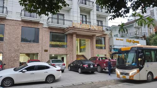 a bus and cars parked in front of a building at Dat Anh Hotel in Hue