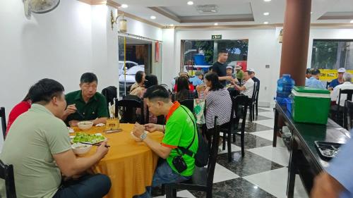 un gruppo di persone sedute a tavola che mangiano cibo di Dat Anh Hotel a Hue