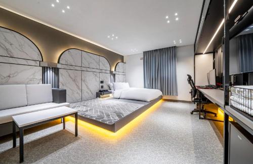 - une chambre avec un lit et un bureau dans l'établissement Reina Hotel, à Busan
