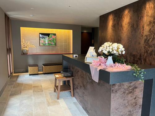 a lobby with a counter with flowers on it at Hotel Naranohamori in Nara