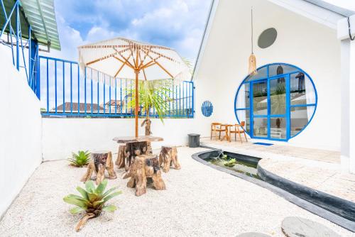 un patio con mesa, sillas y sombrilla en Anny Guesthouse by ecommerceloka, en Darmasaba