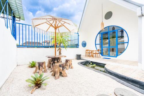 DarmasabaAnny Guesthouse by ecommerceloka的带桌椅和遮阳伞的露台
