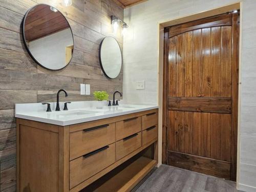 a bathroom with two sinks and a wooden door at A Splashing Good Time in Sevierville