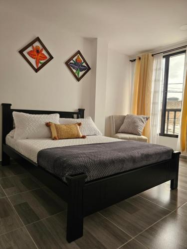 1 dormitorio con 1 cama grande y 1 silla en Zavara Hostal, en Pueblo Tapado