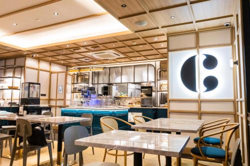 a restaurant with tables and chairs and a kitchen at Staybridge Suites Bangkok Thonglor by IHG in Bangkok