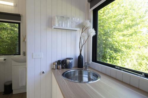 a bathroom with a sink and a window at Tiny Away Benger Garden 2 in Millers Flat