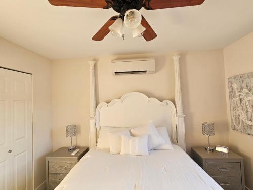 a bedroom with a white bed with a ceiling fan at La Dolce Vita B and B in Osoyoos