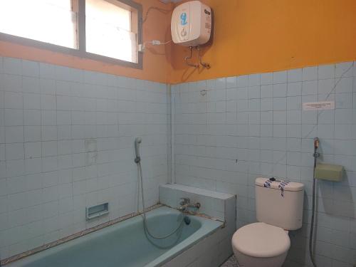 uma casa de banho com um WC e uma banheira em RedDoorz Syariah At Hotel Matahari 1 Jambi em Jambi