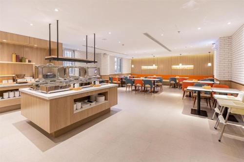 a large kitchen with tables and chairs in a restaurant at Hanting Hotel Anshan Women and Children Hospital in Anshan