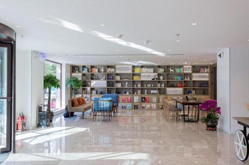 a room with a library with chairs and a table at Hanting Hotel Anshan Women and Children Hospital in Anshan
