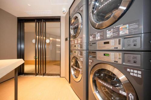 a laundry room with two washer and dryer machines at Ji Hotel Yantai Guanhai Road Fisherman's Wharf in Qianqikuang