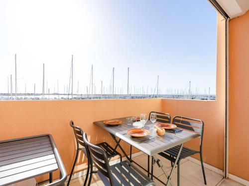 une table et des chaises sur un balcon avec vue dans l'établissement Duplex T2 climatisé, terrasse, proche port - 4 pers. - FR-1-409-254, à Gruissan