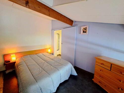 une chambre avec un lit et une commode en bois dans l'établissement Maison mitoyenne climatisée avec piscine, grande terrasse, proche plage à Marseillan - FR-1-326-809, à Marseillan